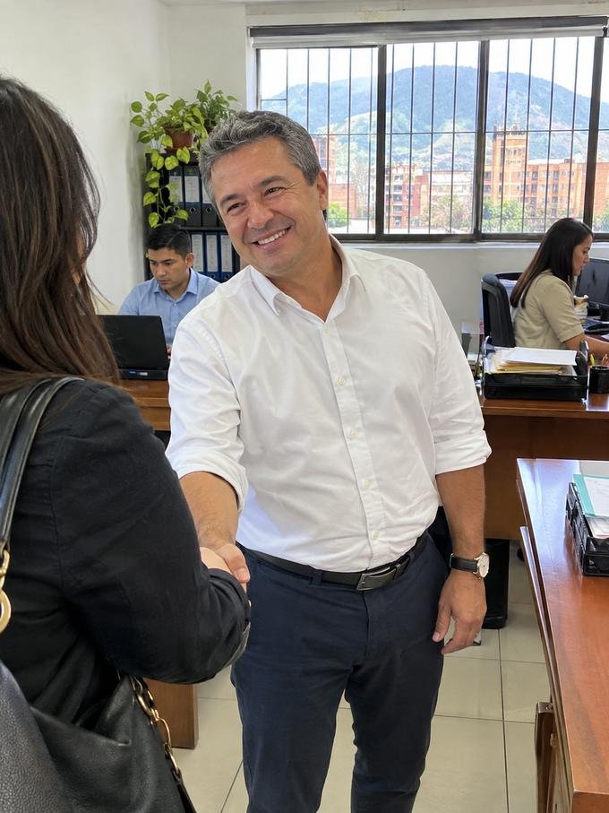 Dueño de una firma contable despidiendo a una clienta en su oficina